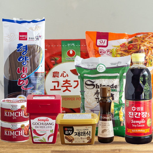 Photo du kit des indispensables de la cuisine coréenne : Naengmyeon, kimchi, gochujang, doenjang, gochugaru, riz, huile de sésame, sauce soja coréenne, nouille dangmyeon.